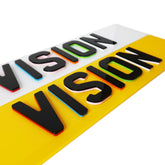 Colorful 'VISION' sign with black text on a white, yellow, and red background