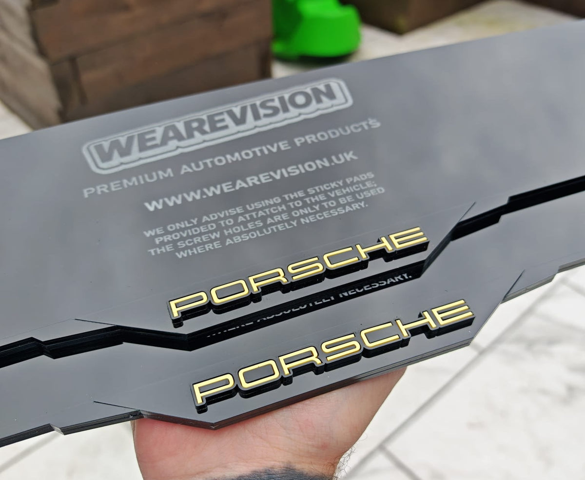 Person holding a Porsche car decal with 'WEAREVISION' branding.